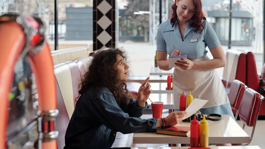Waitress taking an order from a customer in a classic American diner booth