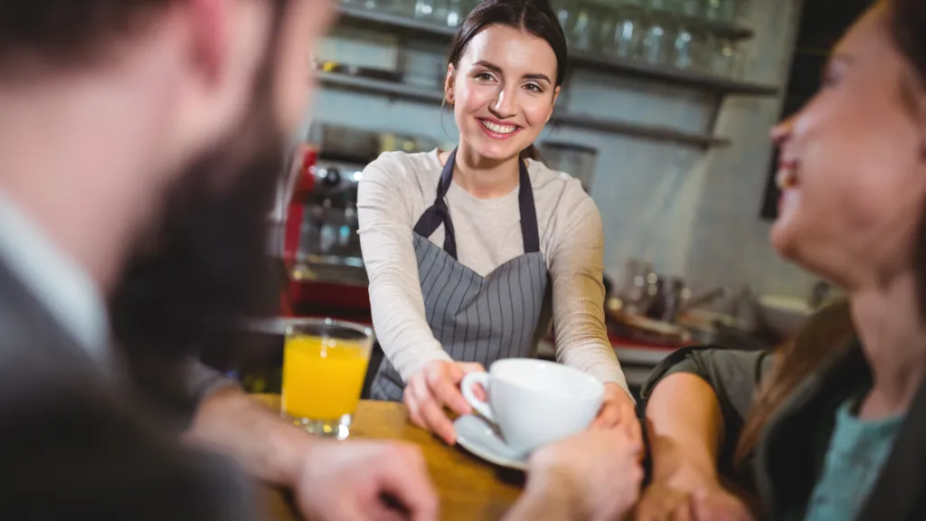 Waitress pouring coffee for customers at a diner counter